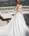 Three-quarter view of the Aurelia beaded French lace ball gown with a full skirt and sweeping lace train