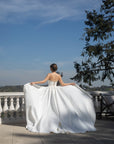 Back view of the Aurelia fitted wedding dress with two detachable train panels held open to show their full volume