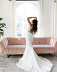 Side view of the Camille Gown showing the fitted crepe silhouette and softly flared bridal train.