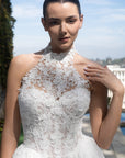 Close-up of the Evangeline wedding dress with a detachable high-neck lace topper and floral corset bodice