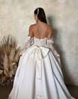 Back detail of the Marcelline ball gown with an oversized detachable bow, French lace bodice, and petite bow accents