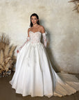 Front view of the Marcelline French lace ball gown with a basque waist, pleated full skirt, and detachable long sleeves