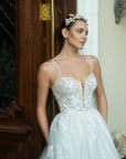 Close-up of the Sylvara floral A-line wedding dress with a sheer illusion bodice, sweetheart neckline, and delicate spaghetti straps