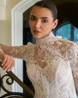 Close-up of the Valentina detachable high-neck French lace jacket with sheer long sleeves and floral lace appliqué