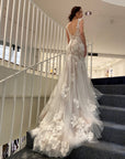 Back view of Amélie fit-and-flare wedding gown featuring a low scoop back, floral lace appliqué and sweeping tulle train.