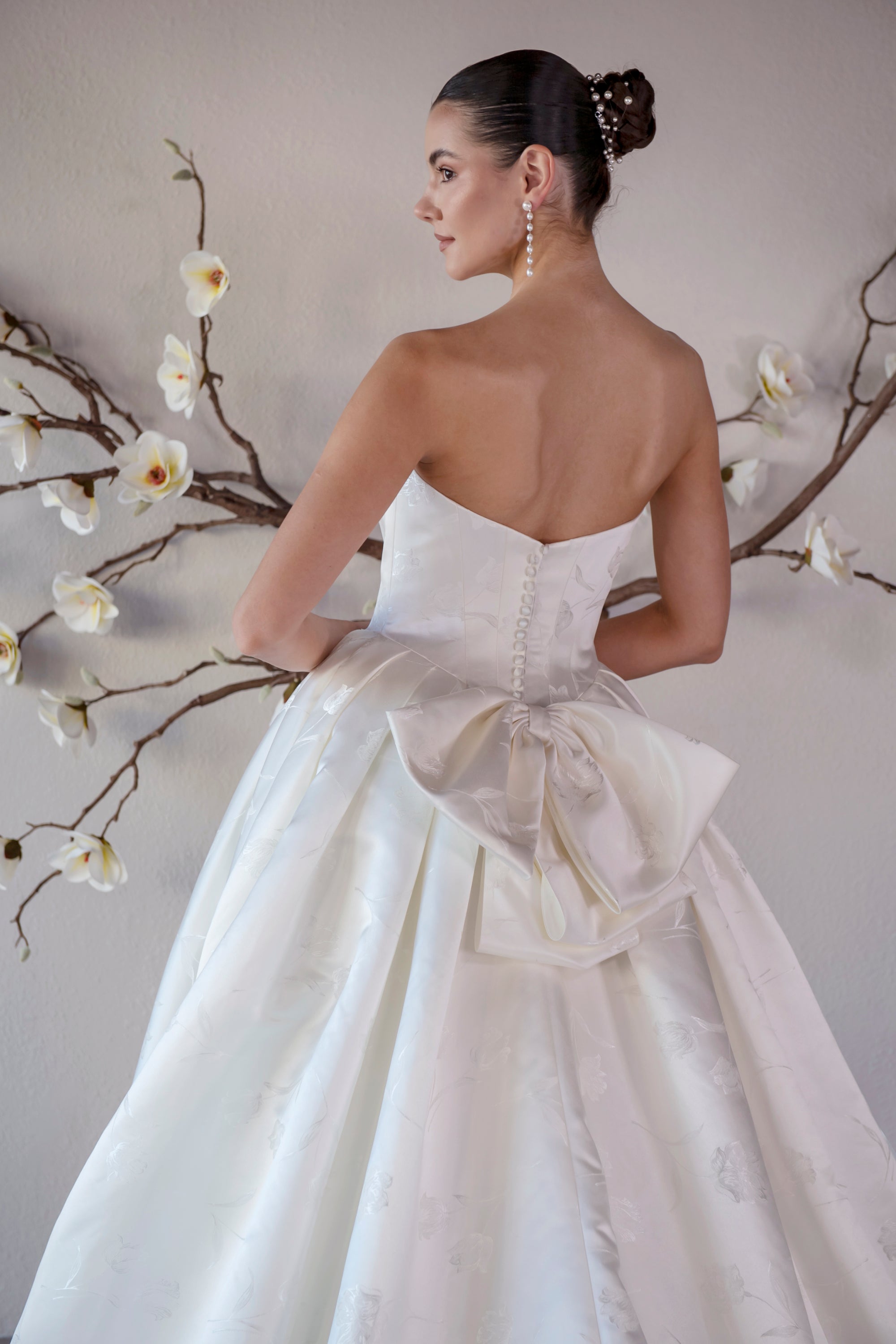 Back detail of the Le Nœud strapless ball gown with a detachable oversized bow and covered buttons