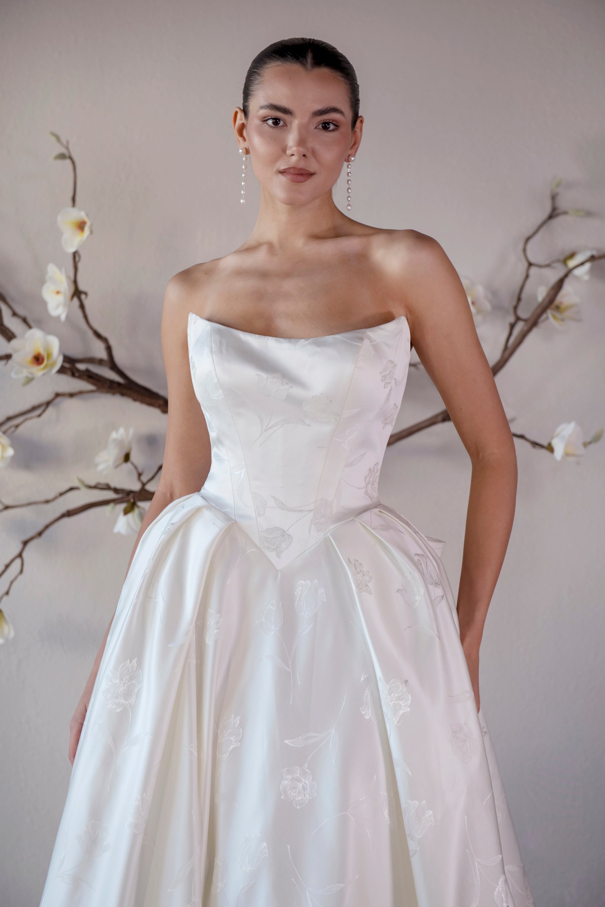 Front bodice detail of the Le Nœud strapless ball gown with a sculpted neckline and pointed basque waist