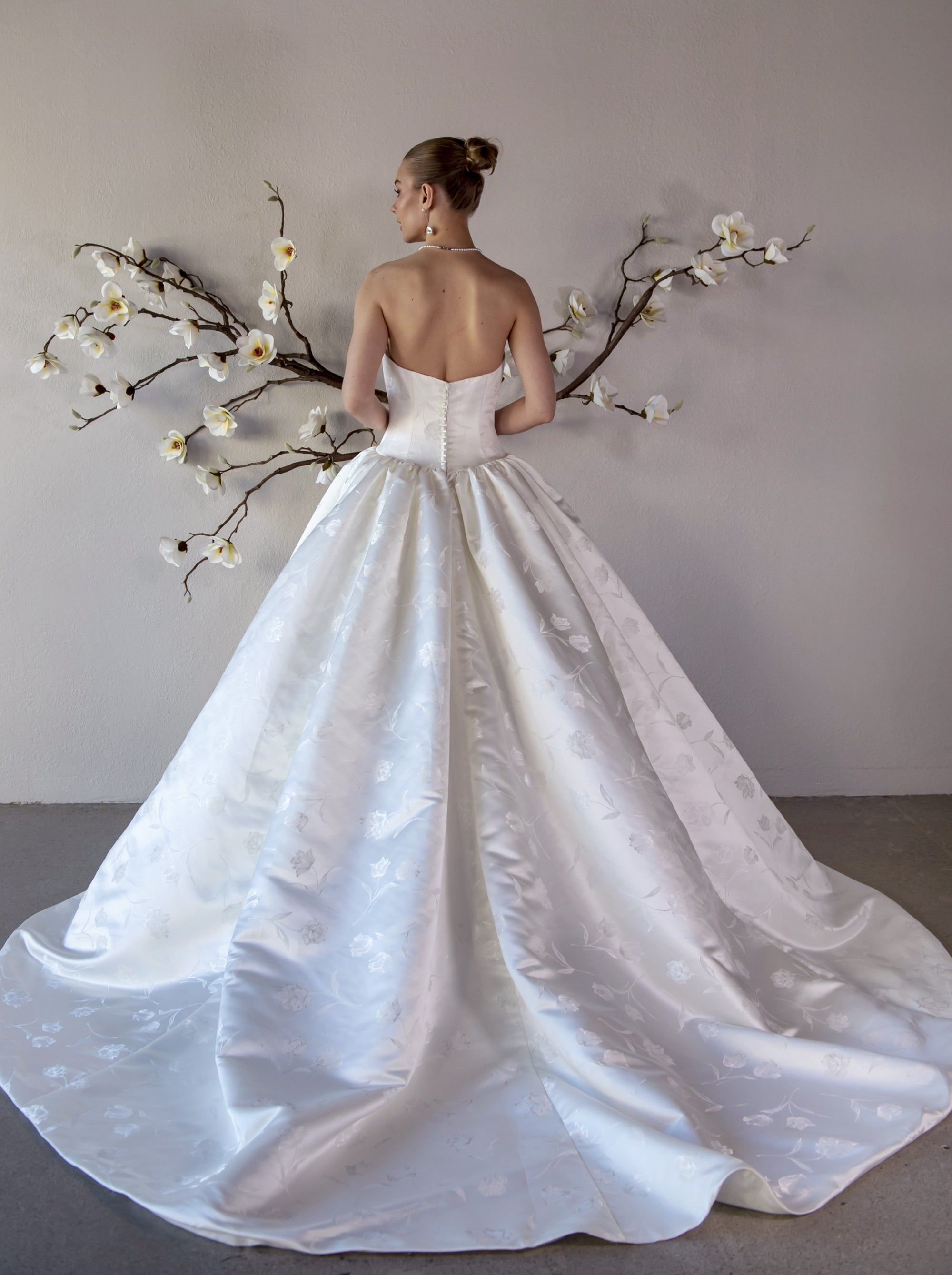 Full back view of the Le Nœud strapless ball gown without the detachable bow, showing the low V-back and sweeping train