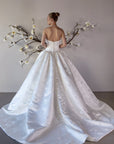 Full back view of the Le Nœud strapless ball gown without the detachable bow, showing the low V-back and sweeping train