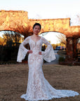 Rosaline lace mermaid wedding dress with illusion neckline and dramatic bell sleeves at Swan Bridal San Antonio.