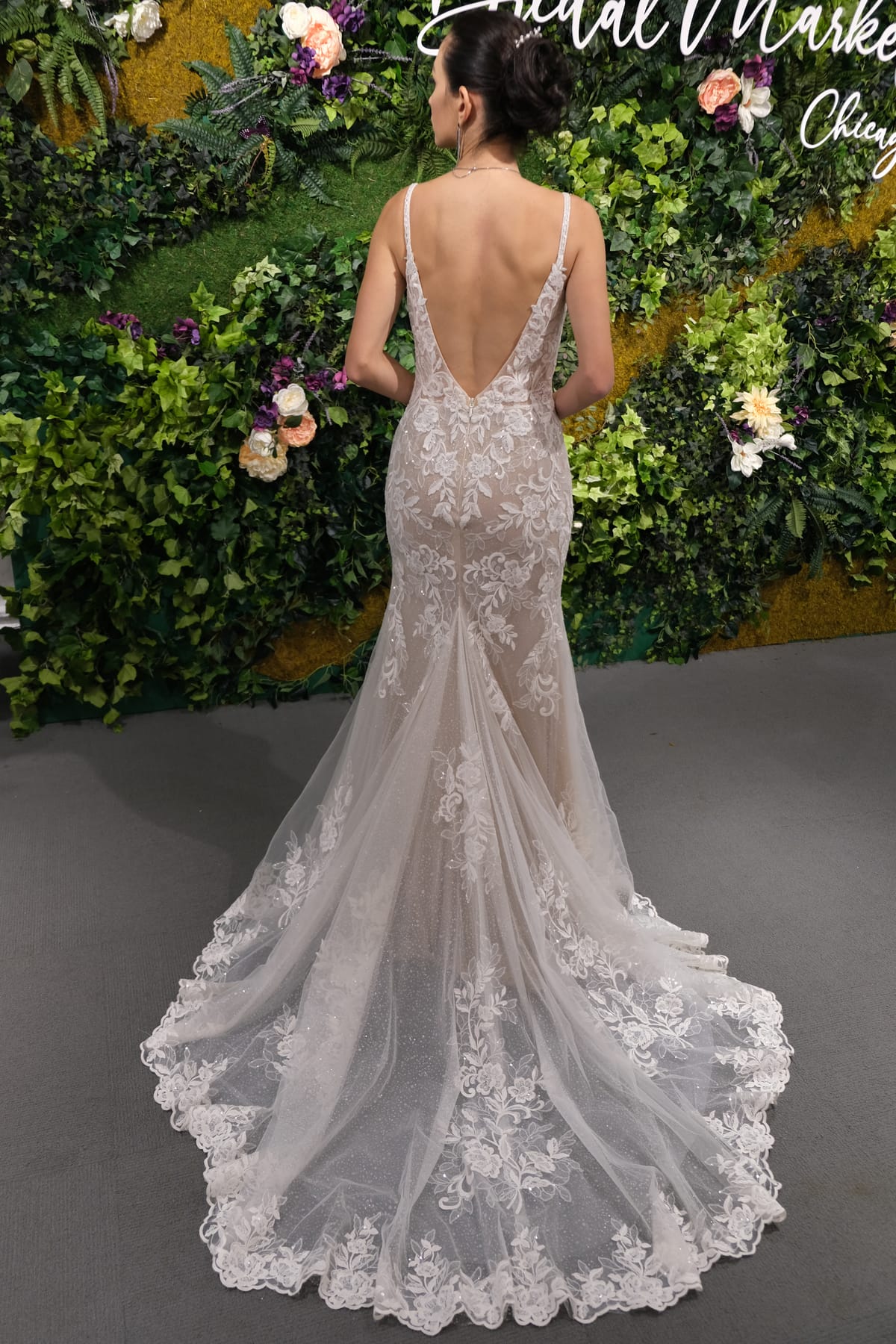 Back view of the Amélie Gown featuring a low V-back, fitted lace silhouette and long floral lace wedding dress train.