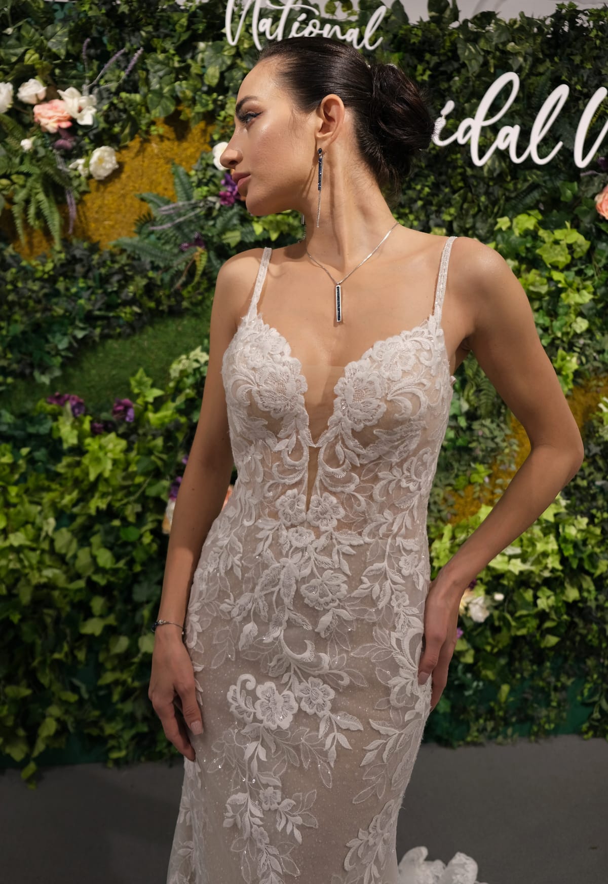 Front view of the Amélie Gown, a fitted lace wedding dress with spaghetti straps, plunging V-neckline and floral lace appliqué.