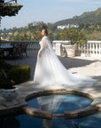 Side view of the Aurelia beaded ball gown styled with a detachable sheer tulle bridal cape and flowing train