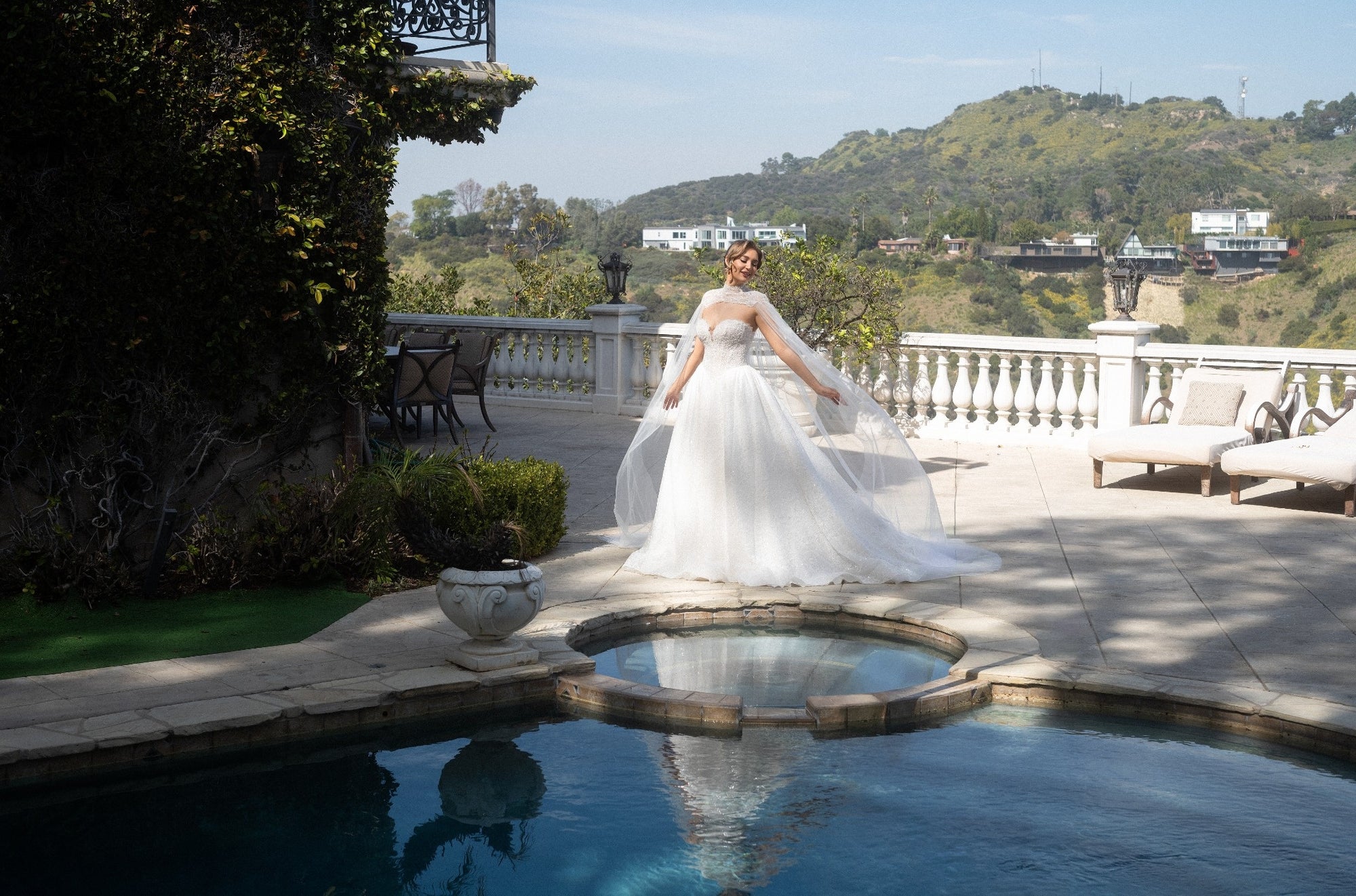 Front view of the Aurelia beaded French lace ball gown styled with a high-neck detachable bridal cape