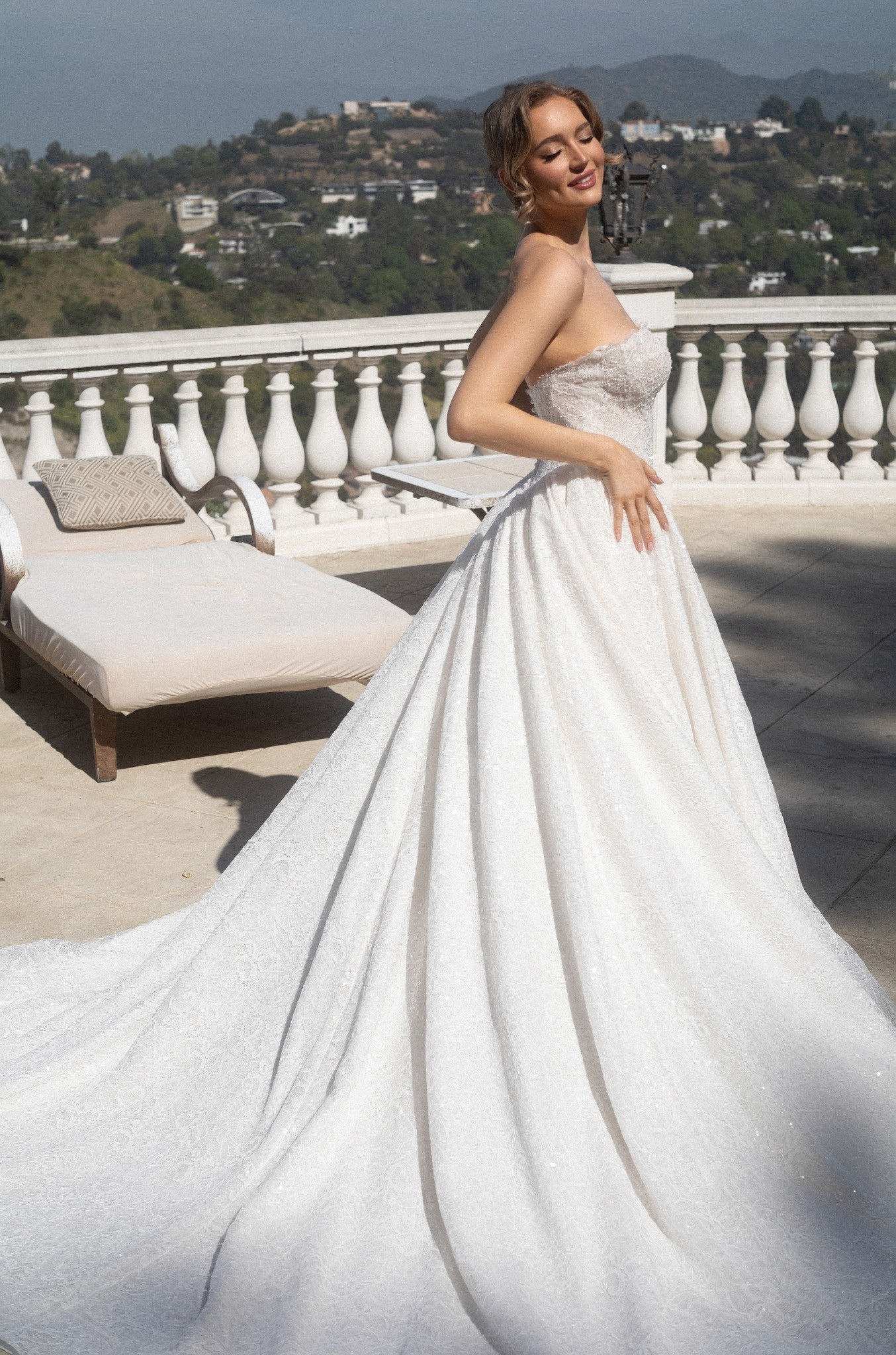 Three-quarter view of the Aurelia beaded French lace ball gown with a full skirt and sweeping lace train