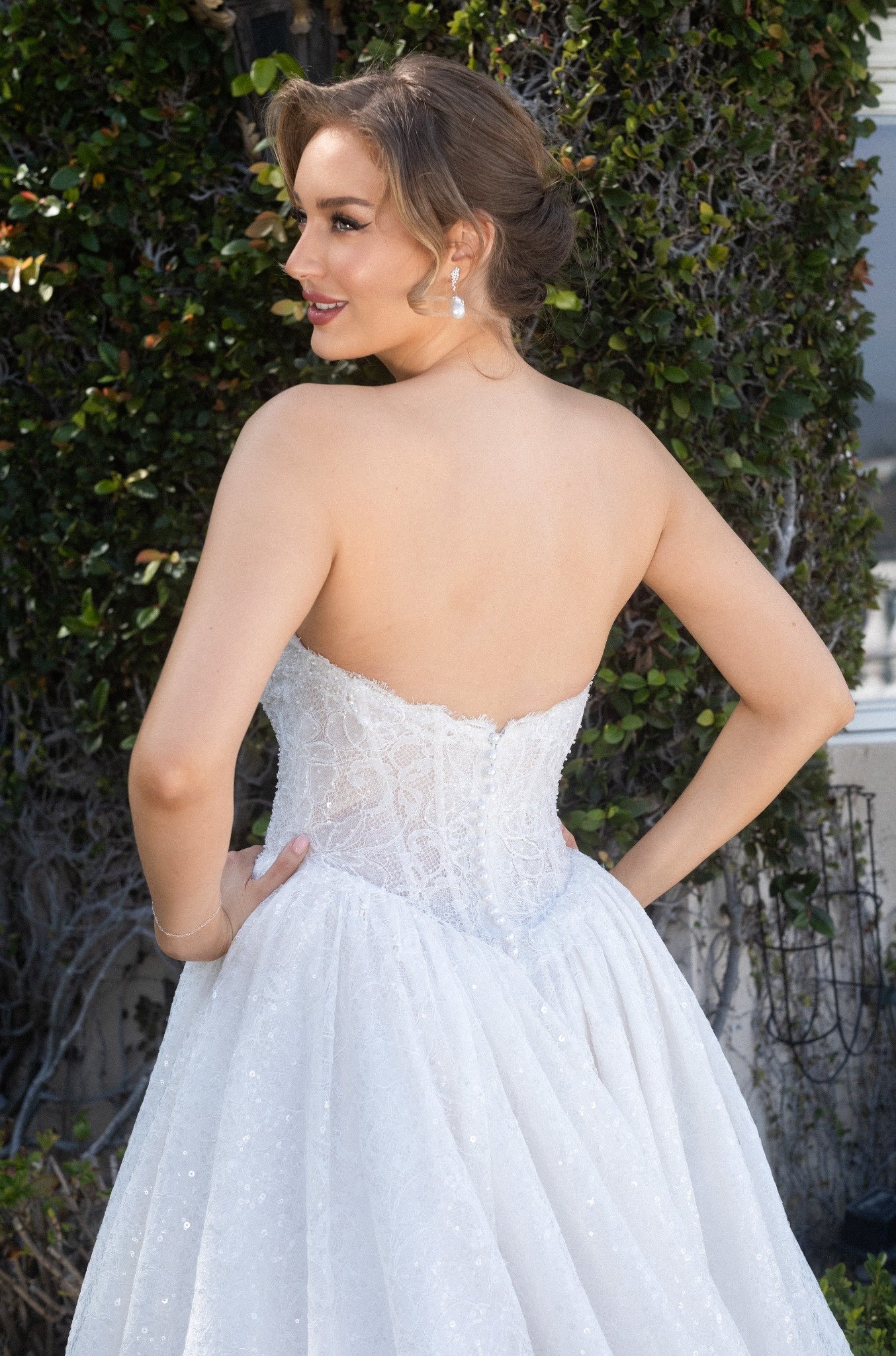 Back bodice detail of the Aurelia French lace ball gown with a low back, corset structure, and covered buttons