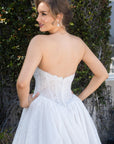 Back bodice detail of the Aurelia French lace ball gown with a low back, corset structure, and covered buttons