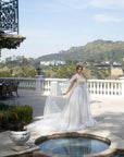Full front view of the Aurelia French lace ball gown with a detachable tulle cape, corset bodice, and voluminous skirt
