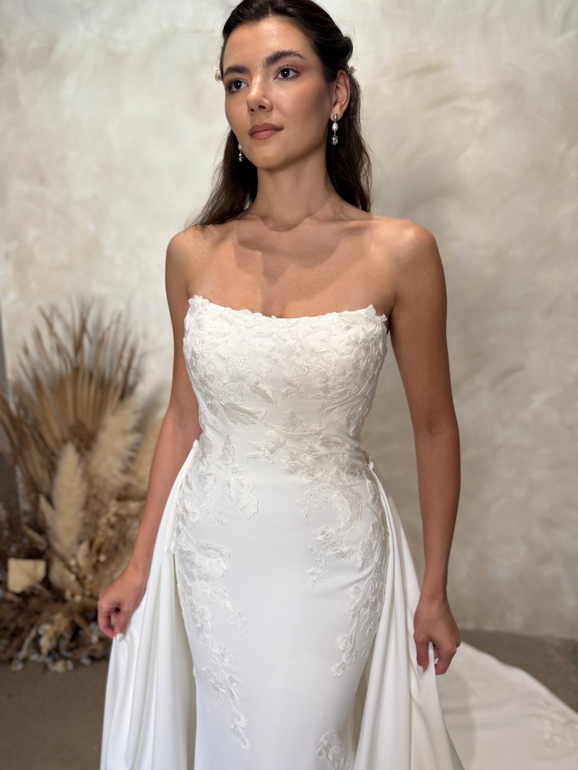 Close-up of the Aveline fitted strapless wedding dress with dimensional floral lace appliqué