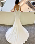 Back view of the Bliss Gown featuring a low V-back, covered buttons and a long sweeping wedding dress train.