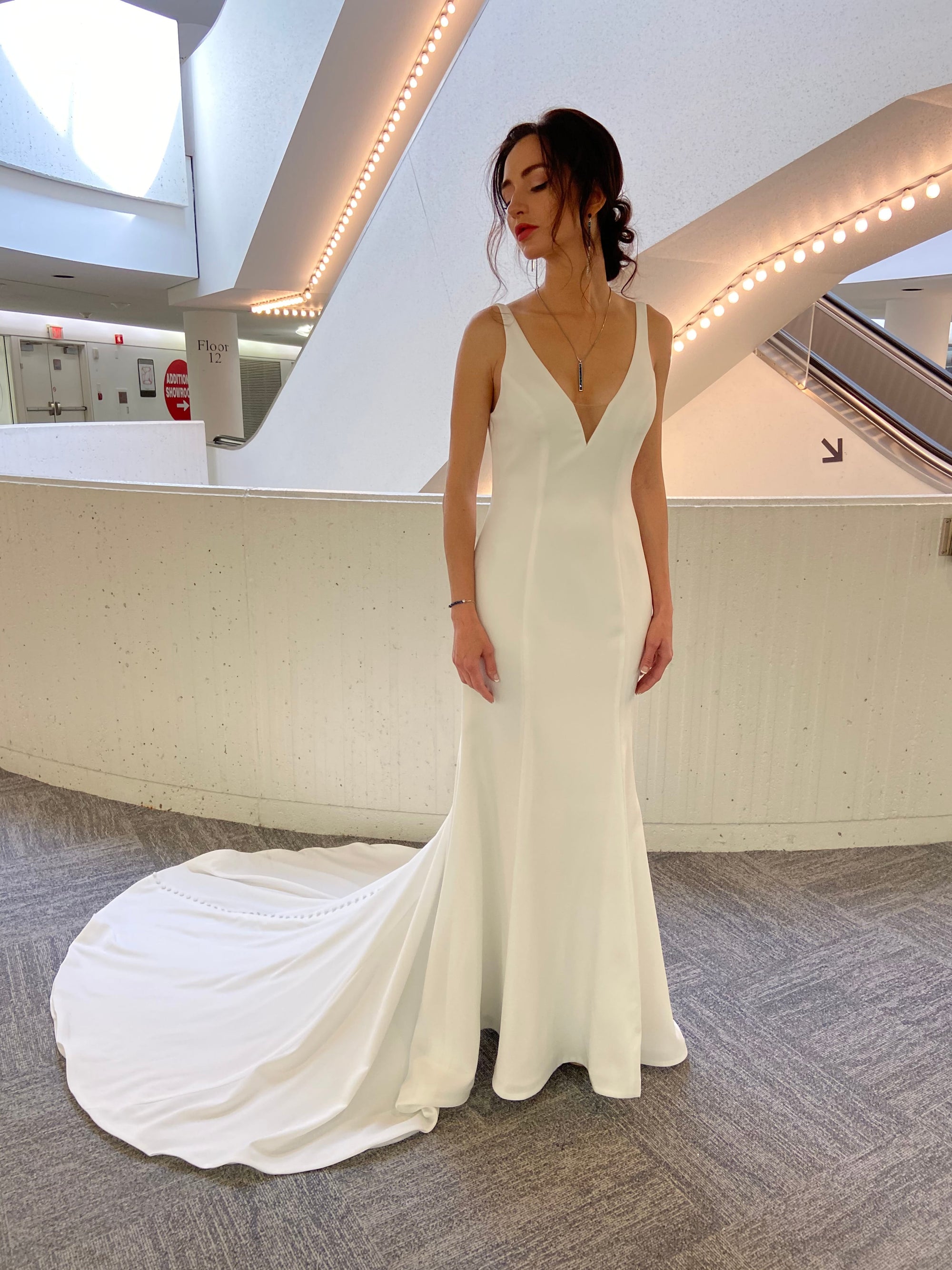 Front view of the Bliss Gown, a minimalist fitted wedding dress with a deep V-neckline and clean silhouette.
