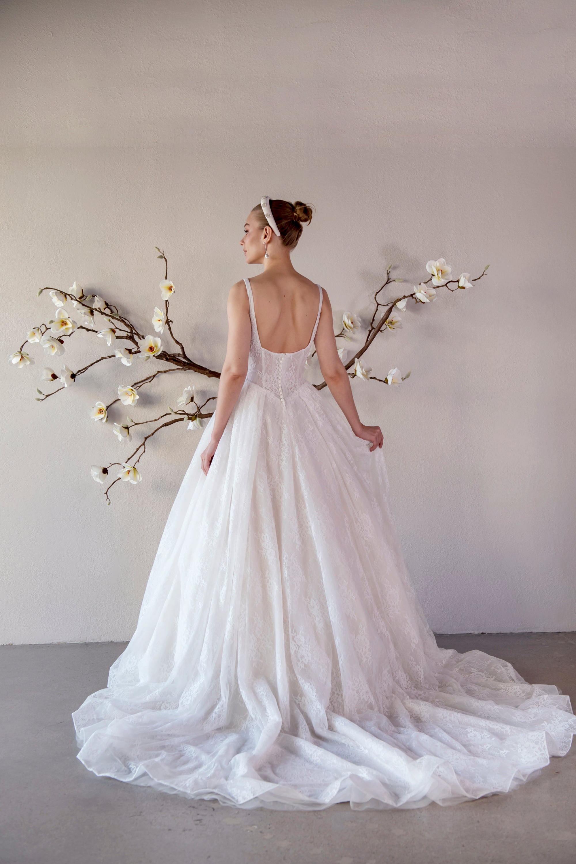 Back view of the Elara lace A-line wedding dress with a low scoop back and flowing lace train