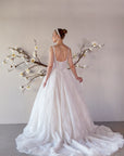 Back view of the Elara lace A-line wedding dress with a low scoop back and flowing lace train