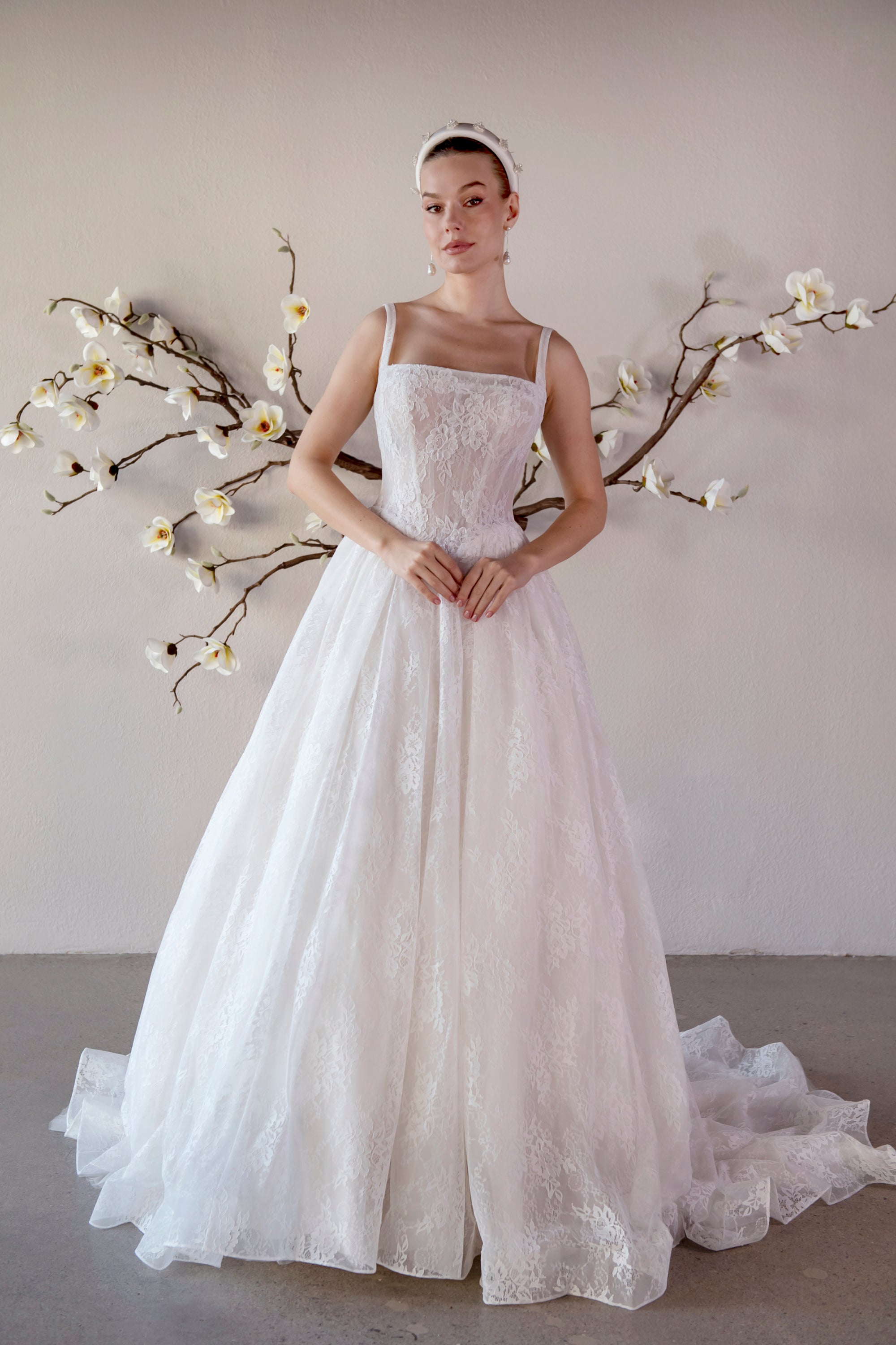 Front view of the Elara square neck lace A-line wedding dress with a fitted bodice and flowing train