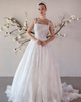 Front view of the Elara square neck lace A-line wedding dress with a fitted bodice and flowing train
