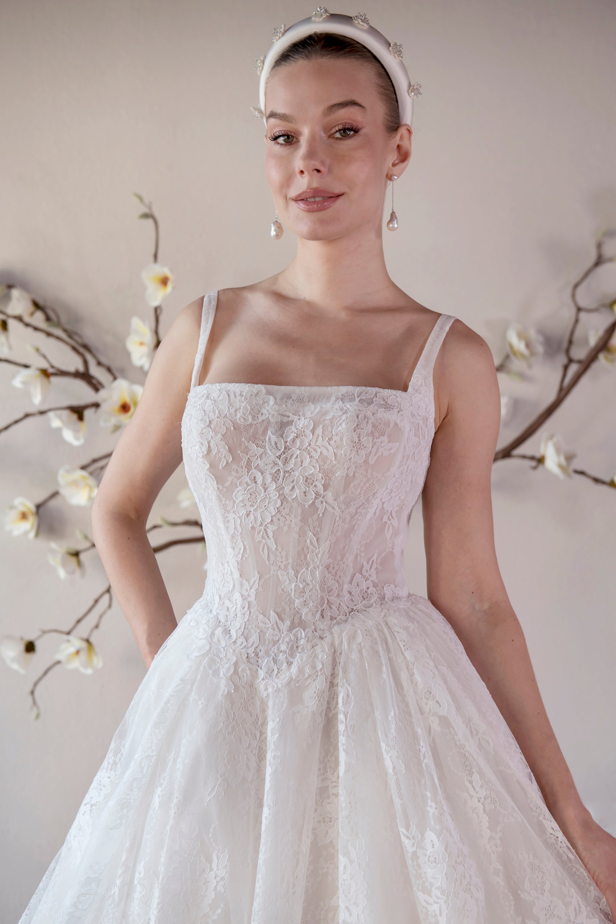 Close-up of the Elara lace A-line wedding dress with a square neckline, shoulder straps, and floral lace bodice