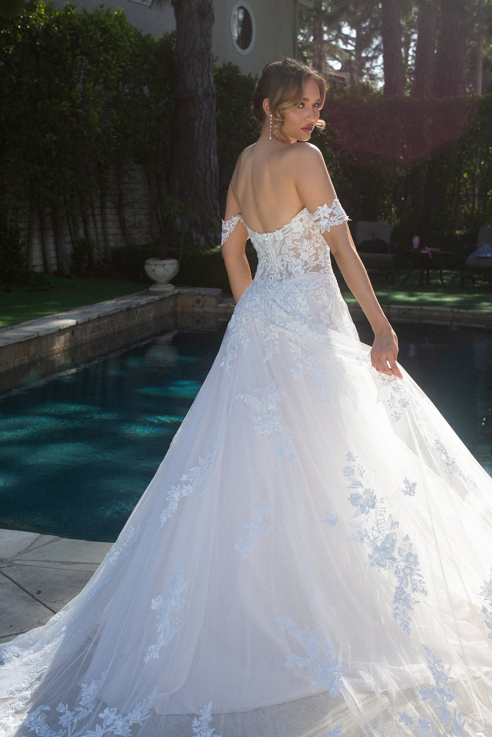 Three-quarter back view of the Elaria 3D floral lace ball gown with an off-shoulder neckline and sweeping train