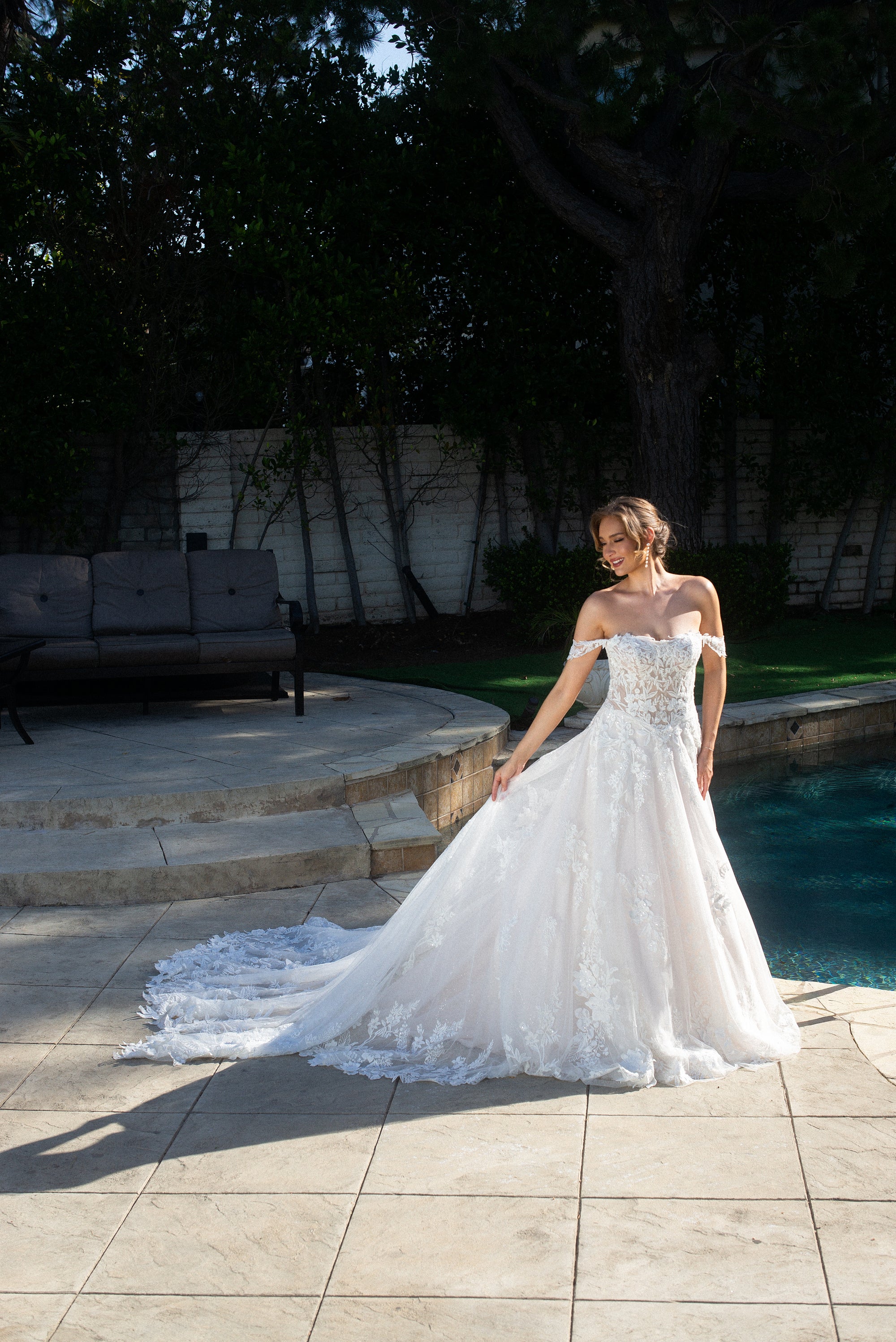 Front view of the Elaria off-shoulder 3D lace ball gown with a basque waist, full skirt, and flowing train