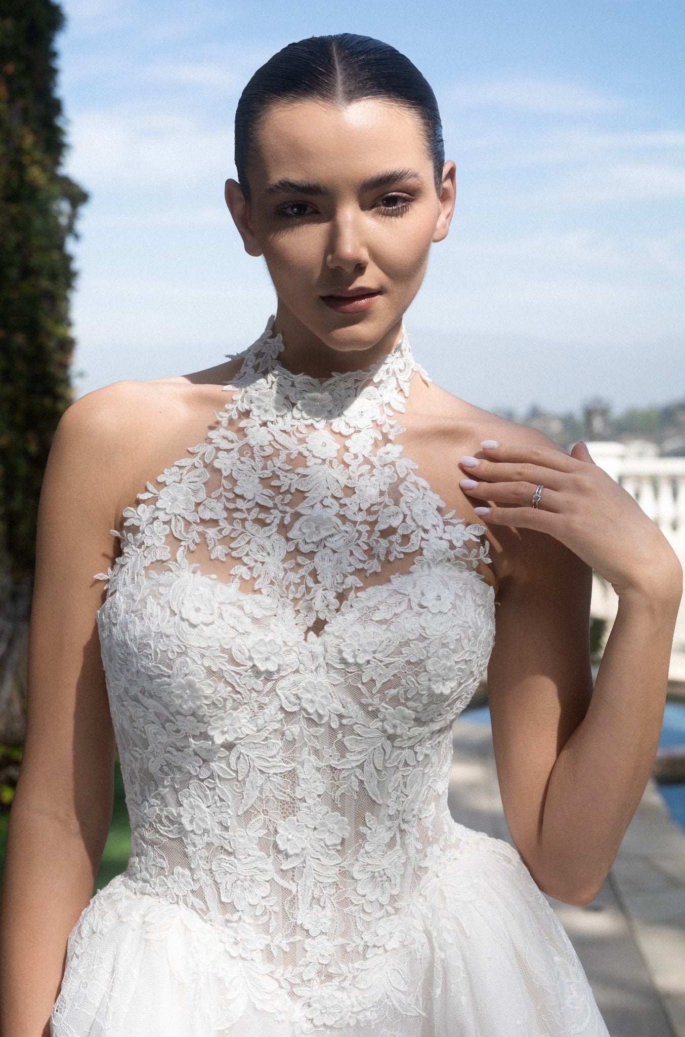 Close-up of the Evangeline wedding dress with a detachable high-neck lace topper and floral corset bodice