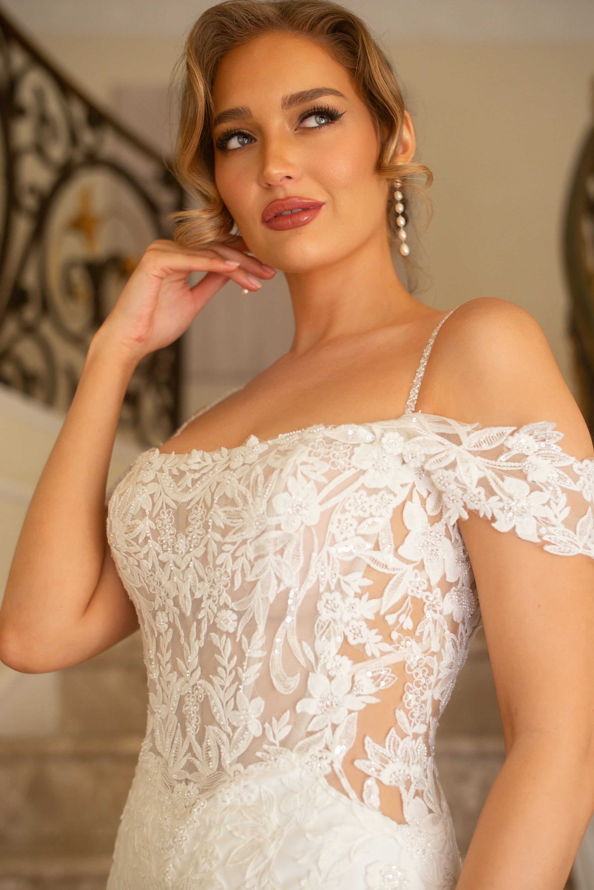 Close-up of the Giardino wedding dress with a sheer floral lace corset bodice, beaded spaghetti straps, and off-the-shoulder sleeves