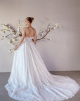 Back view of the Isolde lace ball gown with a low scoop back, covered buttons, and sweeping lace train