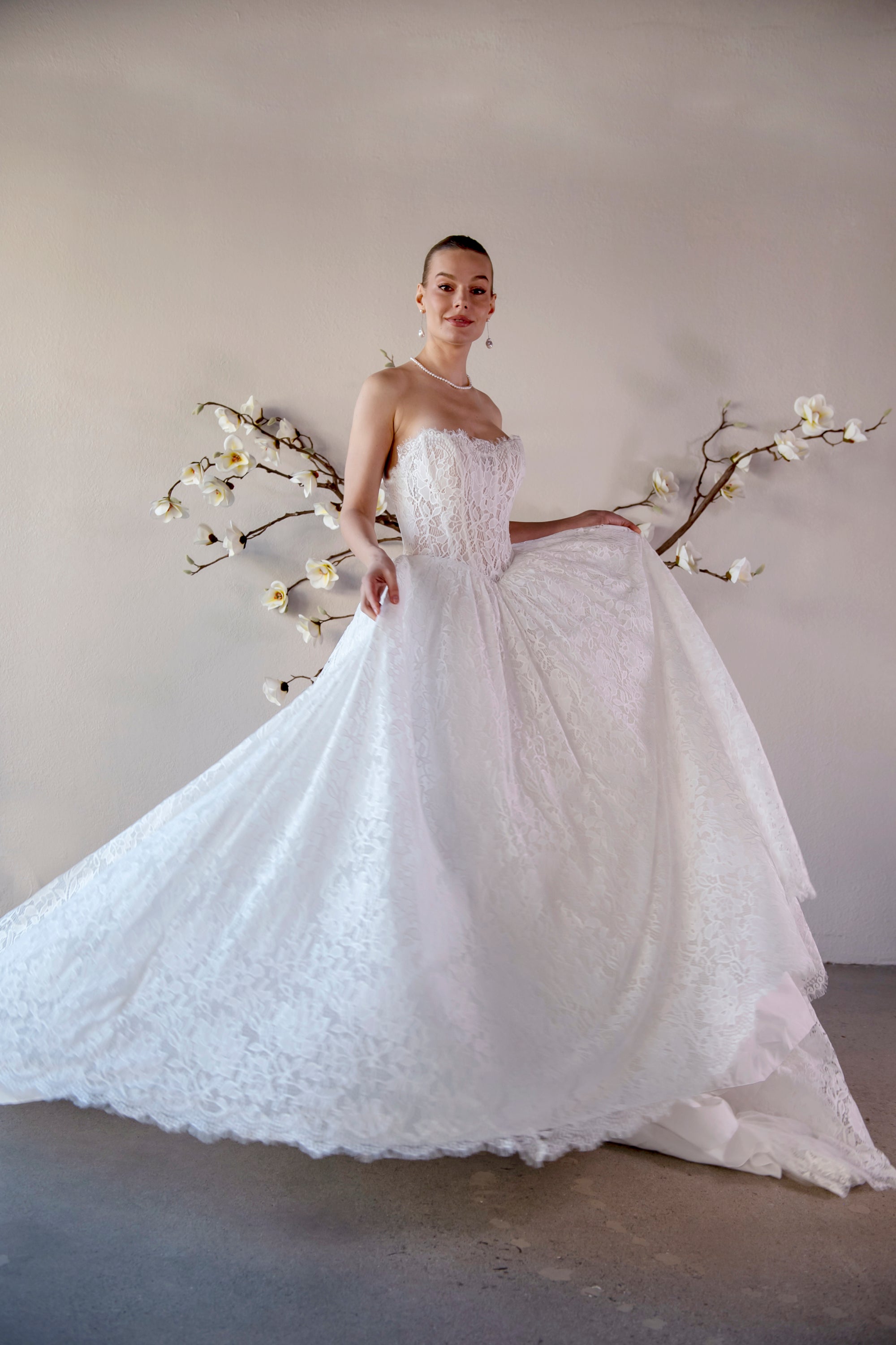 The Isolde strapless lace ball gown in motion, showing its full skirt, basque waist, and dimensional lace texture