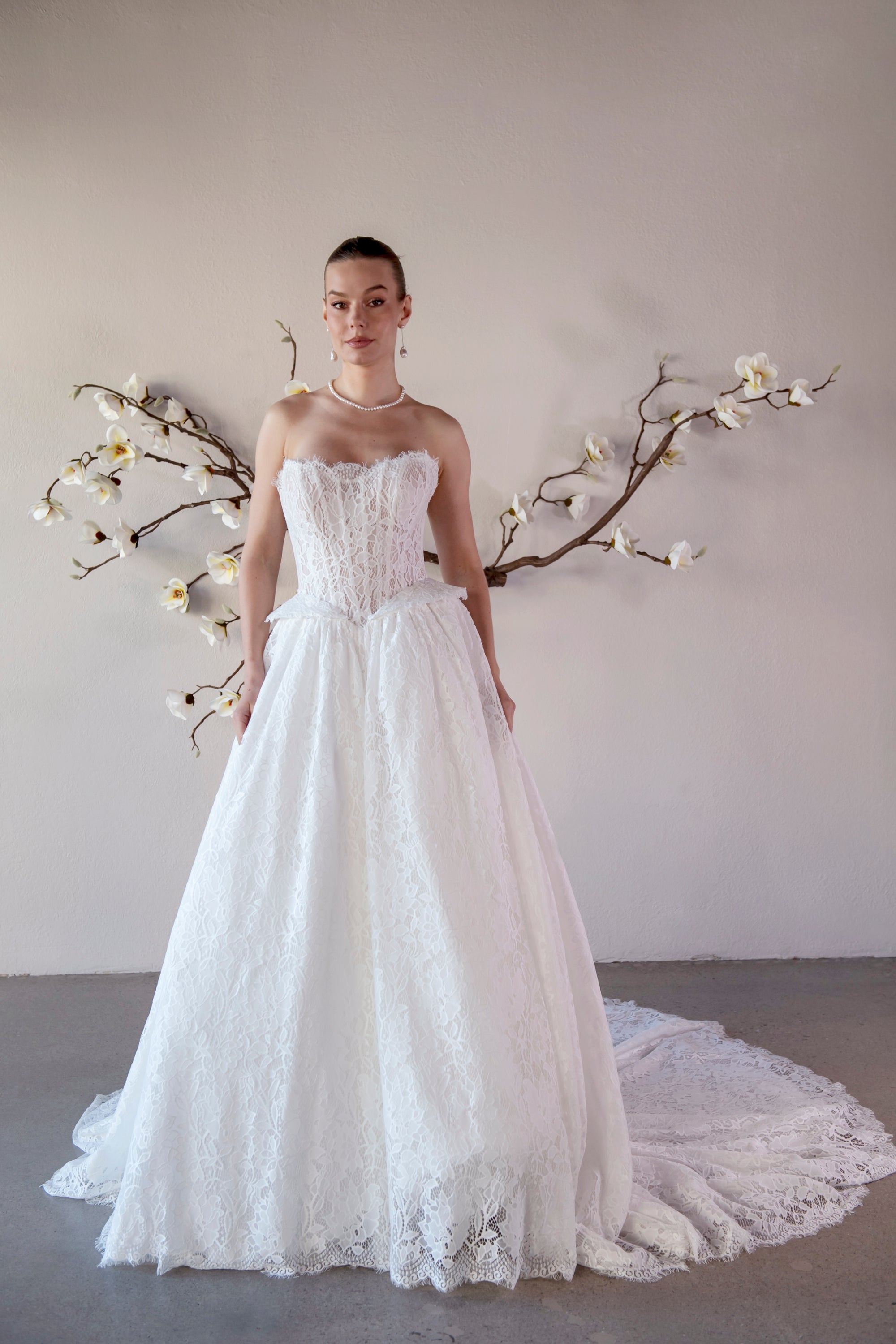 Front view of the Isolde strapless lace ball gown with a structured corset bodice, basque waist, and full skirt