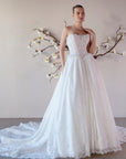 Three-quarter front view of the Isolde strapless lace ball gown with a basque waist, sculptural hip details, and flowing train