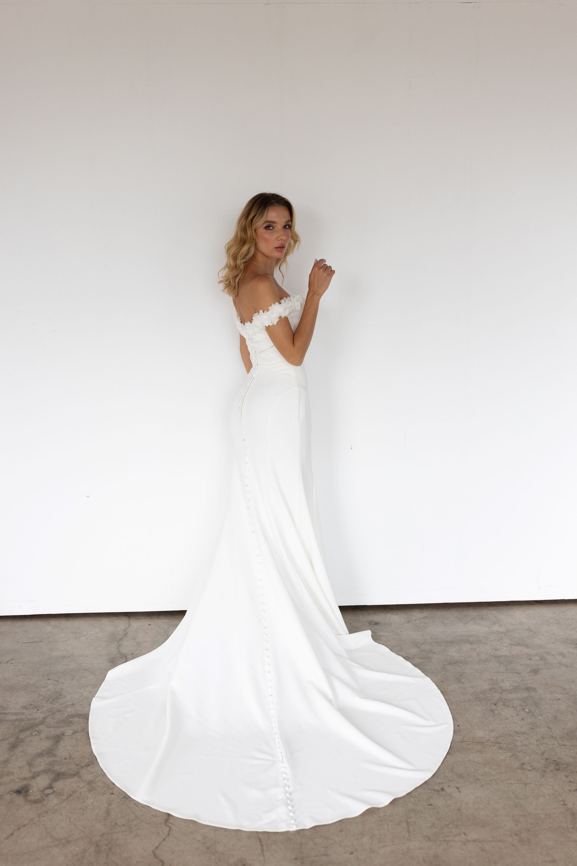 Lisette off-the-shoulder fitted wedding dress with elegant train at Swan Bridal San Antonio