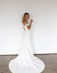 Lisette off-the-shoulder fitted wedding dress with elegant train at Swan Bridal San Antonio