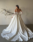 Full back view of the Marcelline ball gown without the detachable statement bow, showing the pleated skirt, petite bow details, and sweeping train