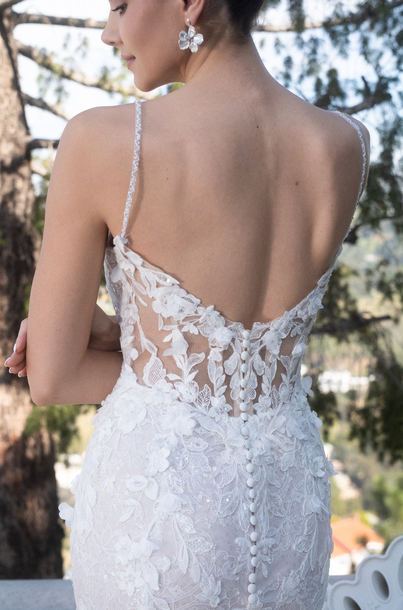 Back bodice detail of the Seraphine 3D floral lace wedding dress with a low illusion back, covered buttons, and delicate sequins