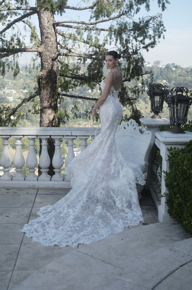 Three-quarter back view of the Seraphine 3D floral lace wedding dress with a fit-and-flare silhouette, subtle sequins, and flowing train