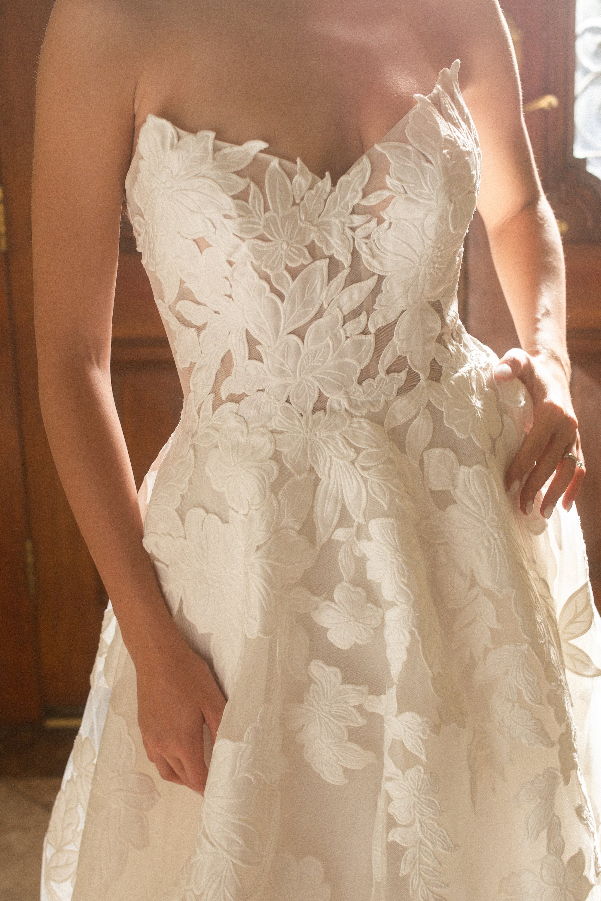Close-up of the Sovereign ball gown featuring a plunging V-cut neckline and dimensional floral appliqué
