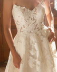 Close-up of the Sovereign ball gown featuring a plunging V-cut neckline and dimensional floral appliqué