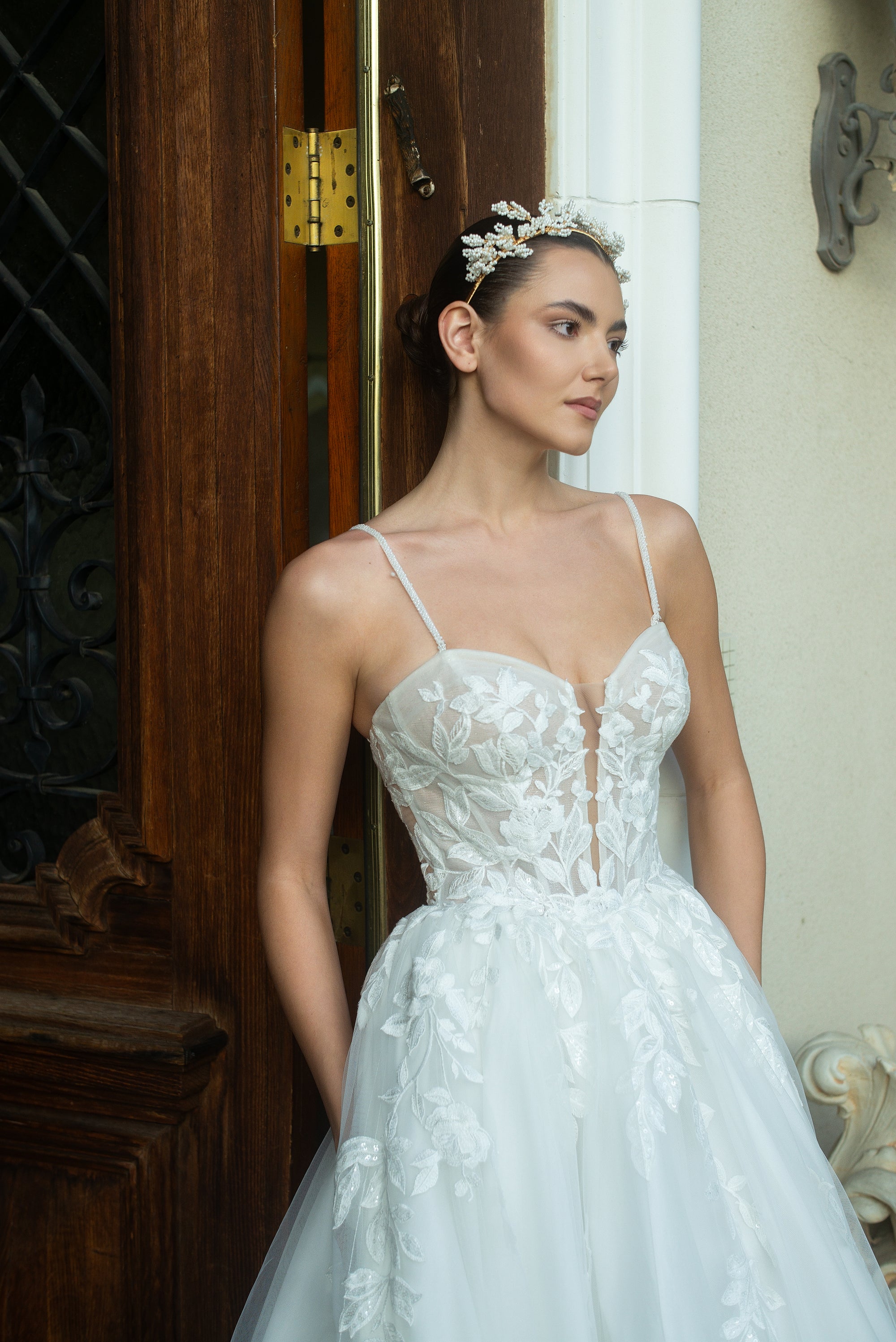 Close-up of the Sylvara floral A-line wedding dress with a sheer illusion bodice, sweetheart neckline, and delicate spaghetti straps