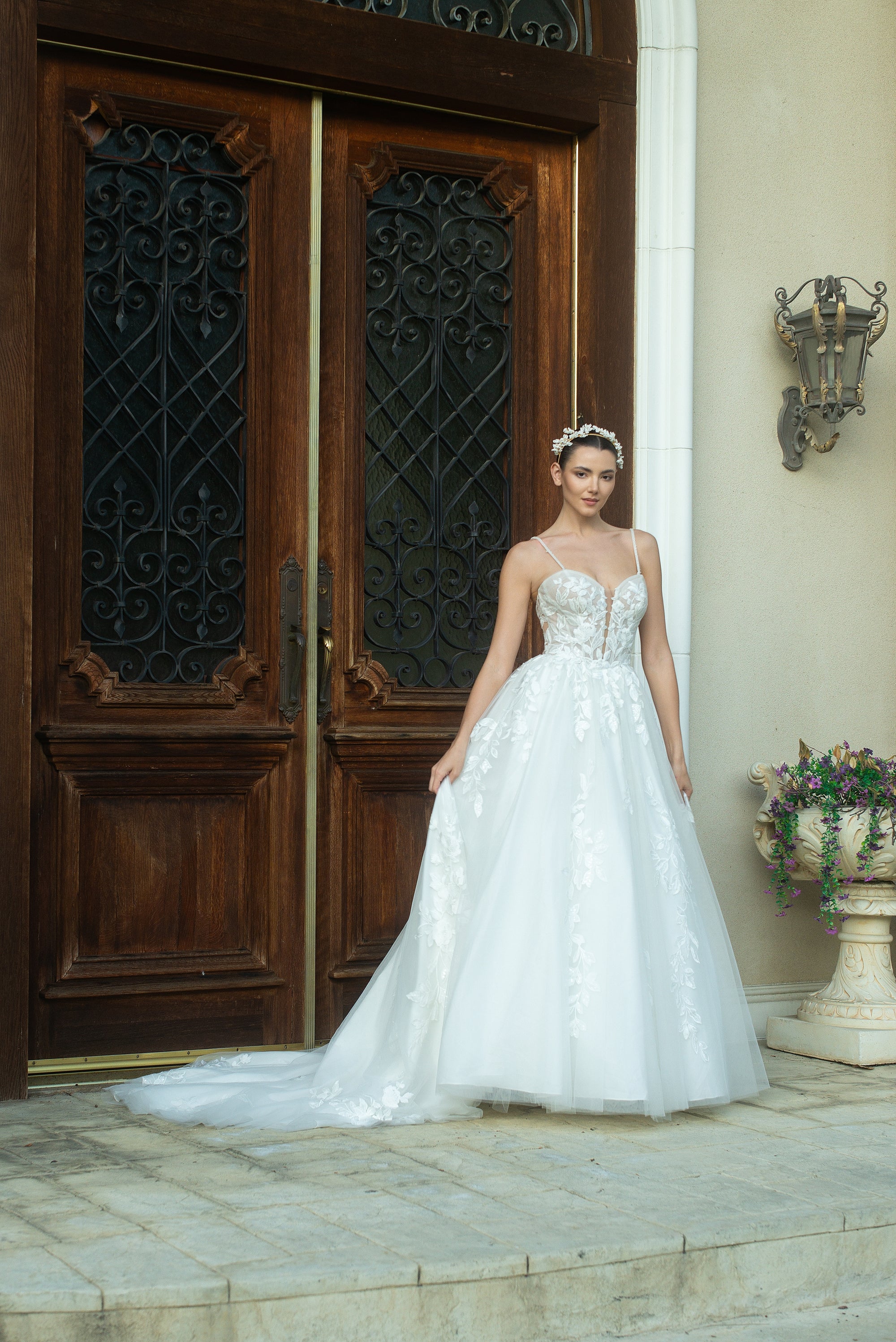 Front view of the Sylvara floral A-line wedding dress with an illusion bodice, spaghetti straps, and a flowing skirt