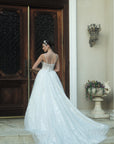 Back view of the Sylvara floral A-line wedding dress with an open illusion lace bodice, spaghetti straps, and a flowing floral train