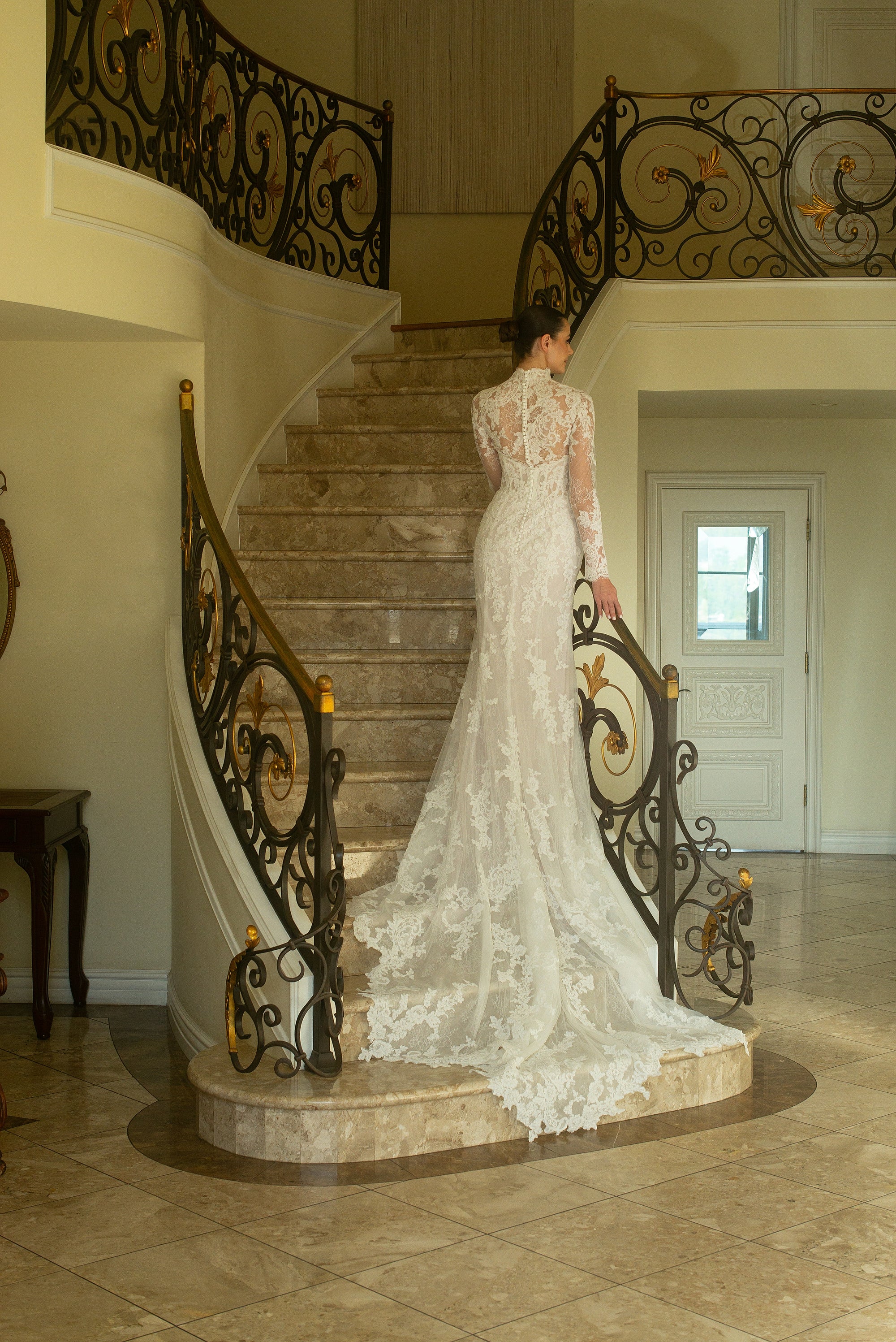 Back view of the Valentina wedding dress with a detachable high-neck lace jacket and sweeping lace train