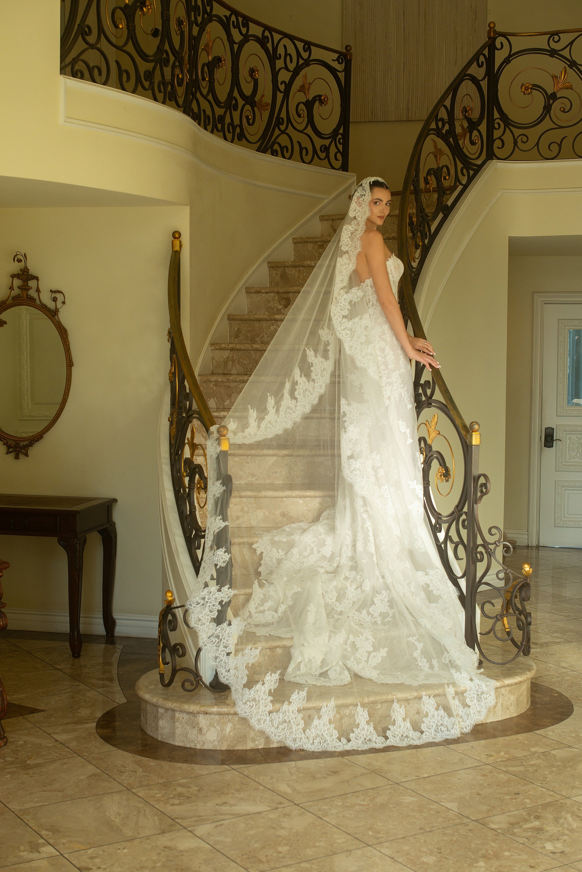 Side view of the Valentina French lace wedding dress styled with a cathedral-length lace veil